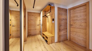 Un couloir avec des portes en bois et un banc.
