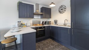 A modern kitchen with dark cabinets, a white countertop, and a built-in oven. - 8 Avery Gardens (Darlington)