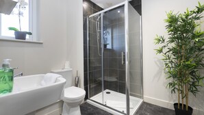 A modern bathroom with a glass-enclosed shower, a white bathtub, and a toilet. - 8 Avery Gardens (Darlington)