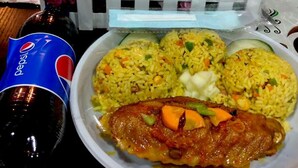A meal with rice, vegetables, and a chicken dish, accompanied by a Pepsi bottle. - Skywood suite  (Abeokuta)