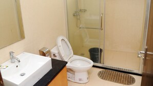 A bathroom with a sink, toilet, and glass-enclosed shower. - Skywood suite  (Abeokuta)