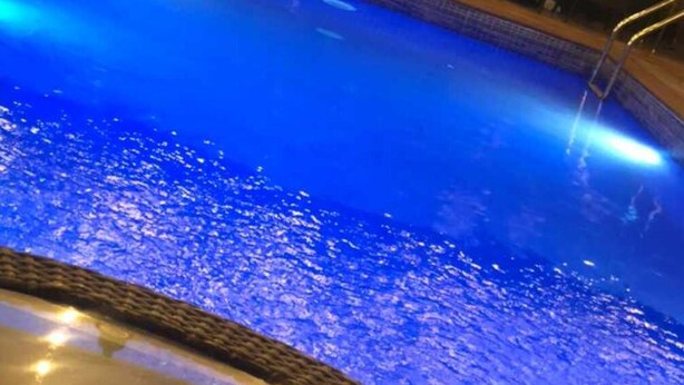 A swimming pool with a tiled edge and a metal ladder. - Skywood suite  (Abeokuta)