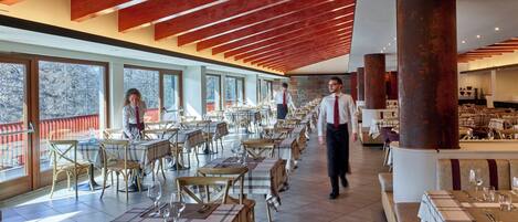 A spacious restaurant with high ceilings, large windows, and a modern interior design.