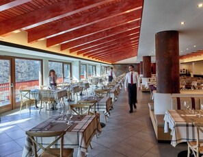 Un restaurante espacioso con techos altos, ventanas amplias y un diseño interior moderno.