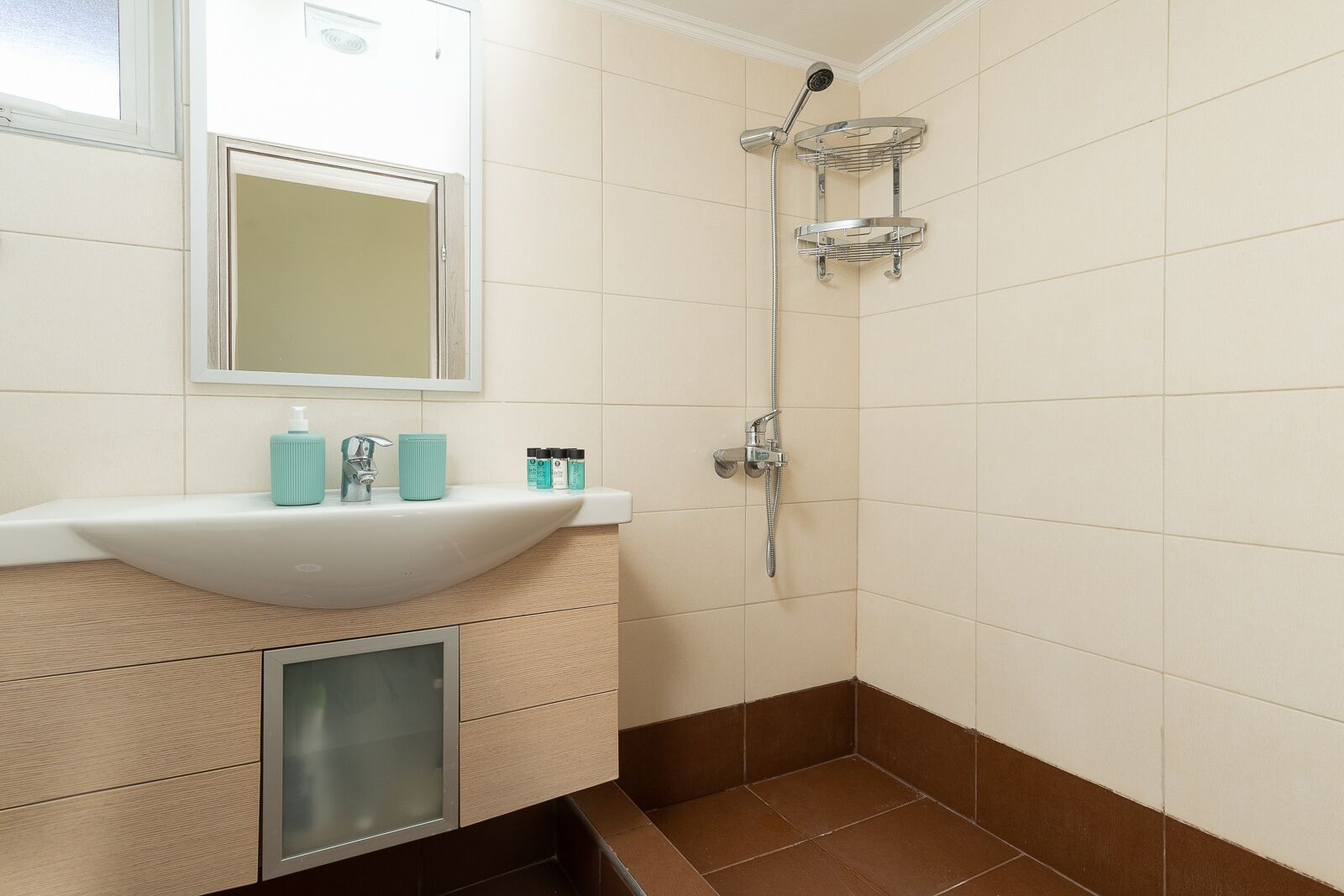 Ein Badezimmer mit Waschbecken, Spiegel und Dusche.