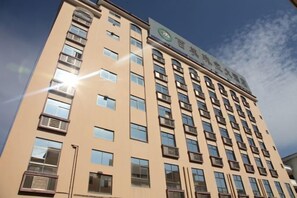 A multi-story building with a series of windows and balconies. - Baimei Zhubao Hot Spring Hotel (Ruili)
