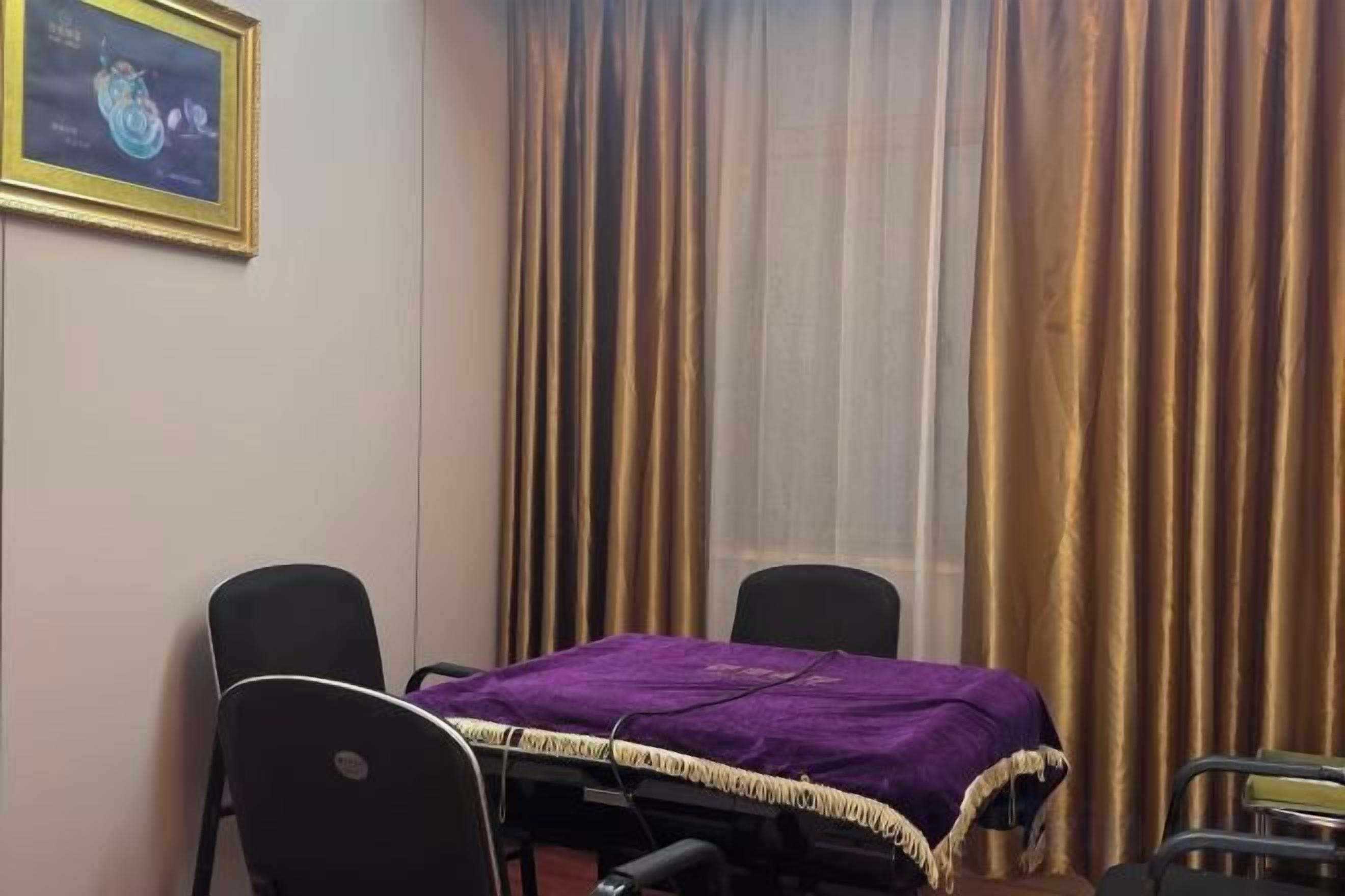 A conference room with a table, chairs, and a purple tablecloth.