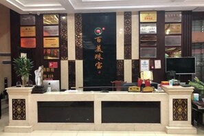 A reception desk with a black backdrop displaying various awards and certificates.