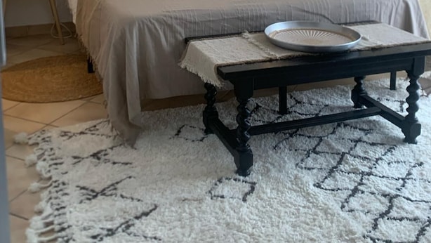 Un dormitorio con cama, mesitas de noche, un espejo y una mesa con bandeja.
