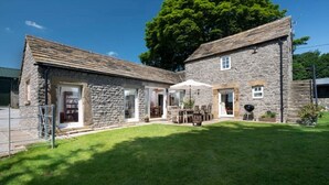 A stone building with a patio area, a covered seating area, and a barbecue setup. - Long Roods Cottage, Monsal Head, near Bakewell (Bakewell)
