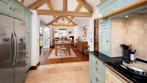A spacious kitchen with wooden beams, a central island, and a large island with a sink. - Long Roods Cottage, Monsal Head, near Bakewell (Bakewell)