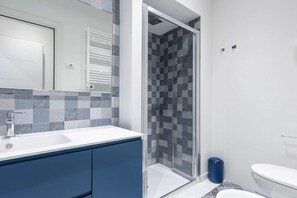 A bathroom with a shower, toilet, and sink. - GuestHost - Siena Historic Center Stylish Flat with Balcony! (Siena)