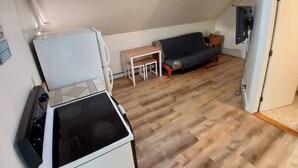 A compact living space with a kitchenette, a sofa, a small table, and a television. - A bedroom balcony with a view to the Ocean.  7 min walk to the beach (Old Orchard Beach)
