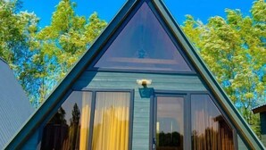 Una casa moderna con tetto triangolare, ampie finestre e un camino ben visibile.