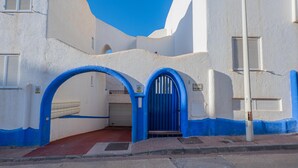 A building with white walls and blue accents, featuring two arched doorways and a central blue door. - Peñon Blanco       . (Níjar)