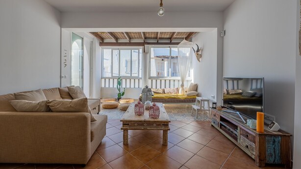 A living room with a sofa, coffee table, TV, and a balcony with a view. - Peñon Blanco       . (Níjar)