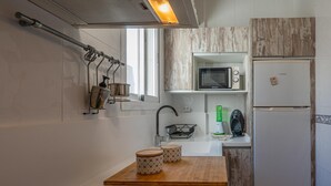 A compact kitchen with a stove, microwave, and refrigerator. - Peñon Blanco       . (Níjar)