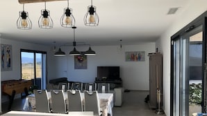 Un comedor moderno con una mesa grande, sillas e iluminación colgante.