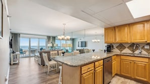 A modern kitchen with wooden cabinets, granite countertops, and a built-in dishwasher.