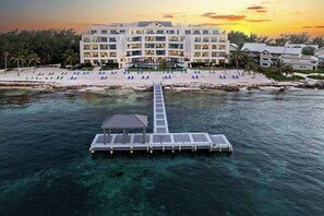 A resort with a beach, clear waters, and a dock.