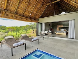 Uma área de piscina com espreguiçadeiras e uma banheira de hidromassagem, uma sala de jantar com mesa e cadeiras, e um quarto com cama e cortinas.