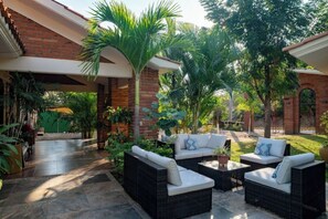 Relax in a serene outdoor space with comfortable seating and lush greenery.
