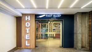 Hotellin sisäänkäynti, jossa on kyltti, jossa lukee: ”SLAVIERO HOTELS -hotellien nopeauniset sviitit”.