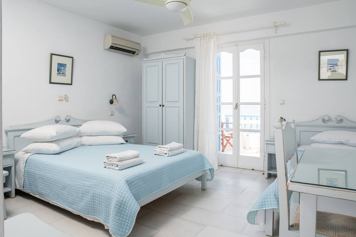 Un dormitorio con cama, armario, escritorio y silla.