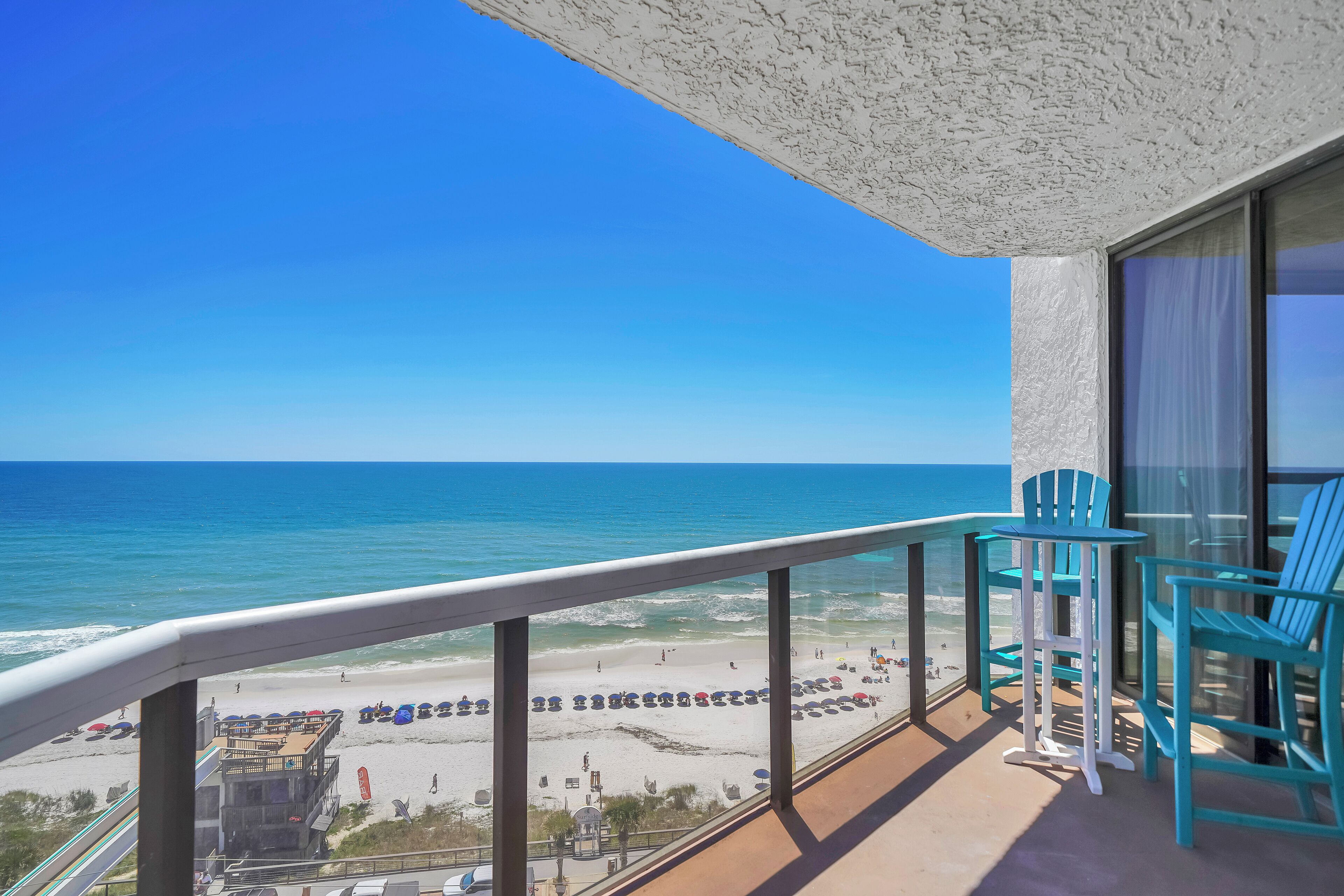 Un balcon avec vue sur la plage et l’océan.