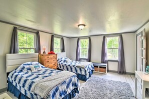 A bedroom with two beds, a dresser, a desk, and large windows. - The Maine Retreat! Pet Friendly! (Milbridge)