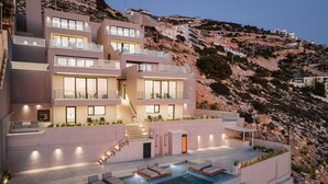 Un edificio moderno de varios pisos con piscina, zona de estar exterior y una escalera que lleva a los niveles superiores.