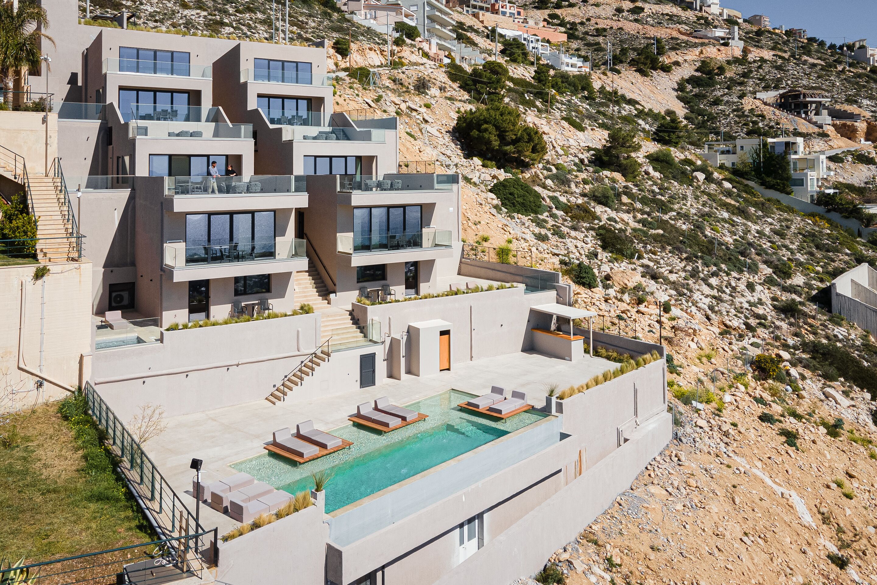 A modern building with multiple balconies and a rooftop pool area.