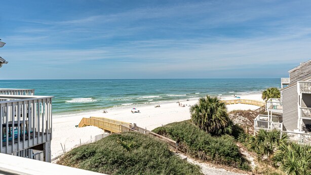 A beach view with a wooden boardwalk, beach umbrellas, and a sandy beach. - We are ready to Sea Ya! on the Cape! 3/3.5 Gulf Front - SPECIALS! (Port St. Joe)