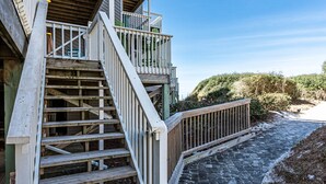 A wooden staircase leading to a balcony with a stone pathway beside it. - We are ready to Sea Ya! on the Cape! 3/3.5 Gulf Front - SPECIALS! (Port St. Joe)