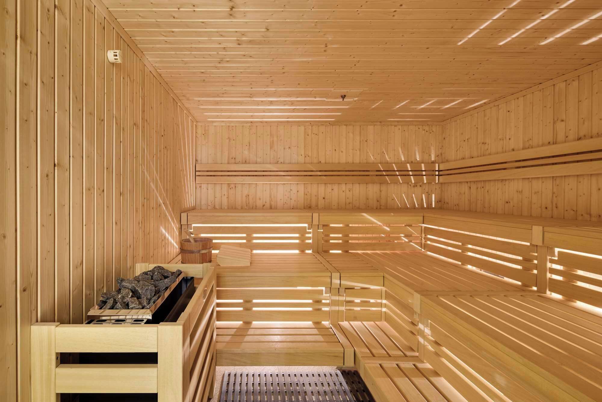A sauna with wooden benches and a bench with a heat source.