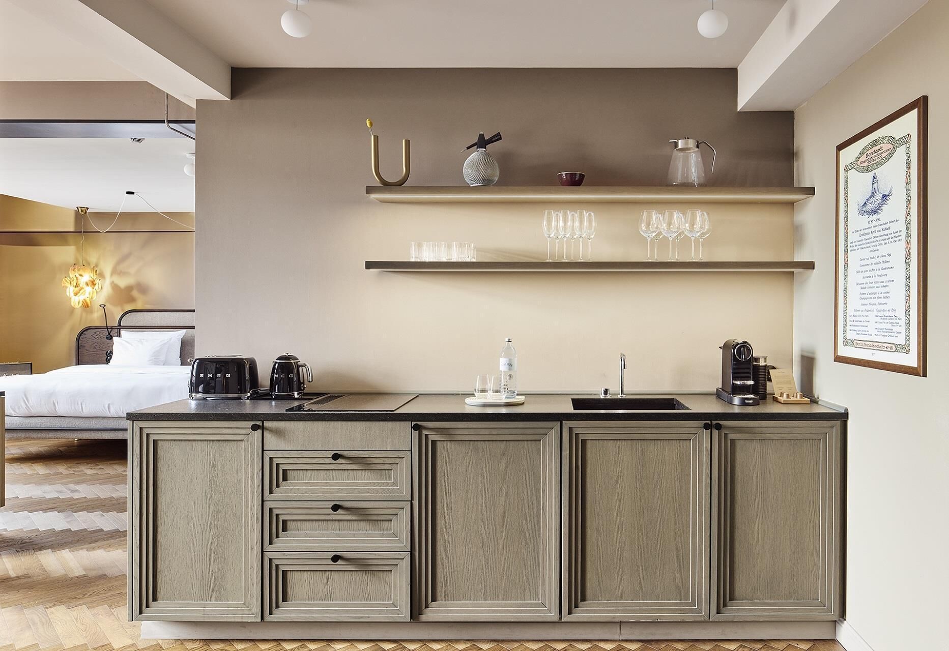 A modern kitchen with a built-in island, a bed with a headboard, and a dining area with a table and chairs.