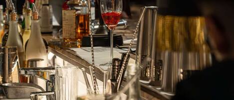 A bartender pouring a drink into a glass.