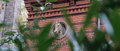 Un edificio de ladrillo con un ventanal circular que muestra la cabeza de un caballo.