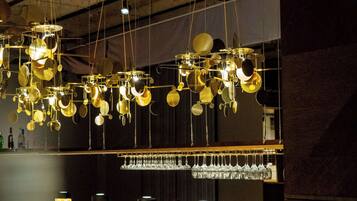 A bar area with hanging light fixtures and a wine rack.