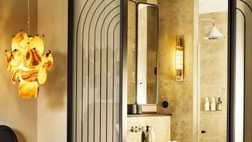 Quarto de hotel moderno com uma cama grande, banheiro com espelho, pia e porta-toalhas.