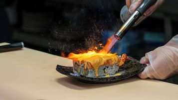 Un plato de sushi siendo asado con un soplete.