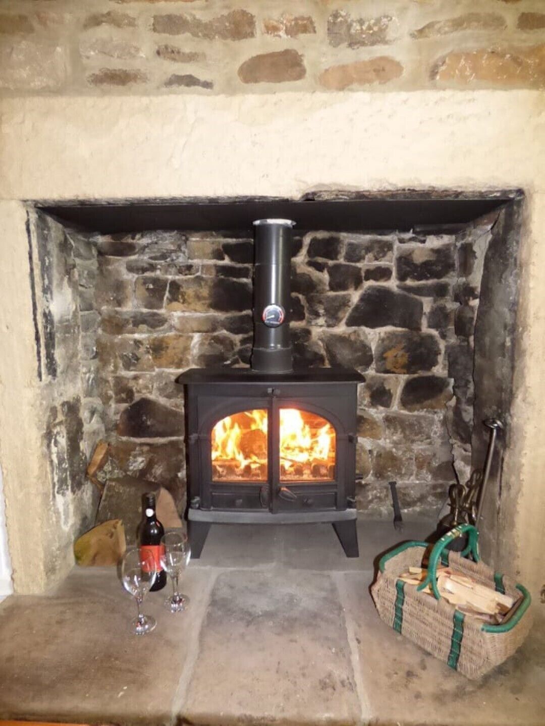 A stone fireplace with a wood-burning stove.