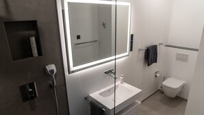 A modern bathroom with a large mirror, a sink, a toilet, and a shower. - THE Newsha Signature Home (Muelheim an der Ruhr)