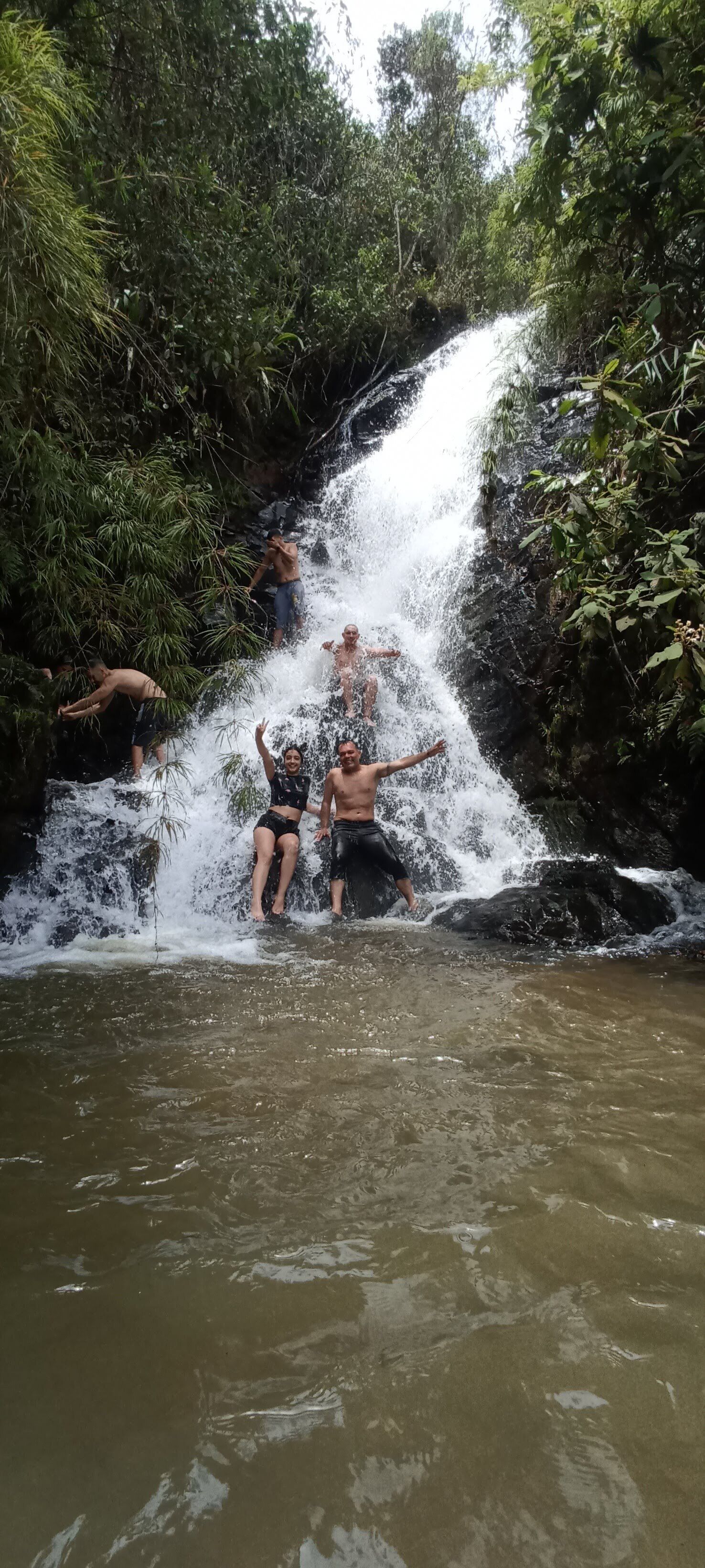 Una cascada con gente disfrutando del agua.