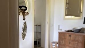 Une pièce avec un meuble en bois, un petit tabouret et une commode bleue.
