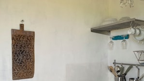 Une cuisine équipée d’une cuisinière intégrée, d’un évier et d’un luminaire suspendu.