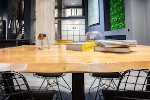 Relax in a stylish room with a large table, comfortable chairs, and a unique green wall.