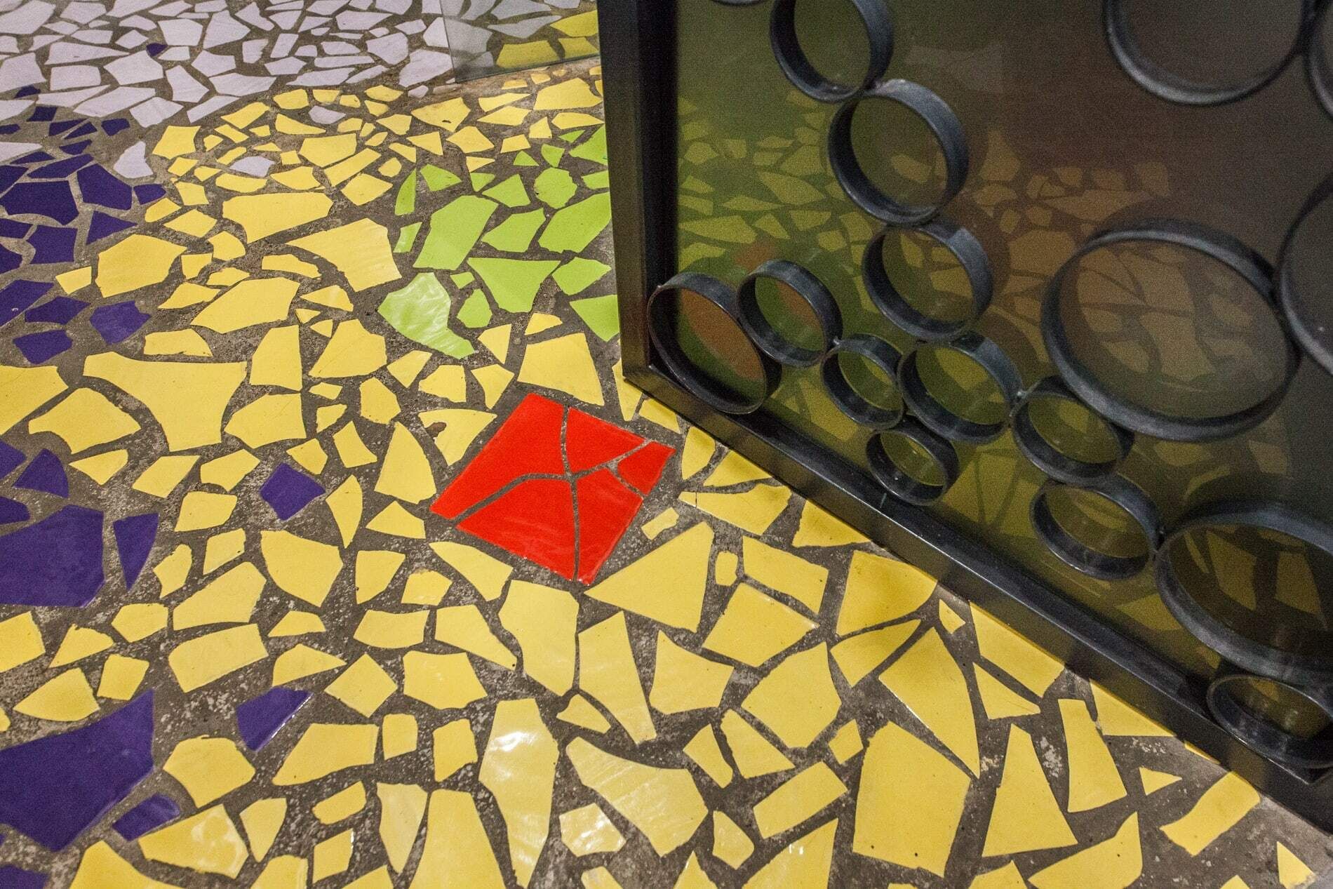 A mosaic floor with a red square tile.