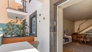 A modern interior with a dining area, a staircase, and a living space. - Holiday Home "Casa das Andorinhas" with Private Terrace & Wi-Fi (Câmara de Lobos)