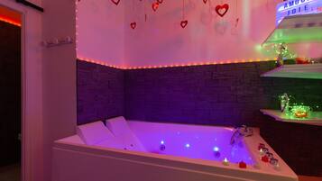 Une salle de bain moderne avec une baignoire, des décorations en forme de cœur et un néon.